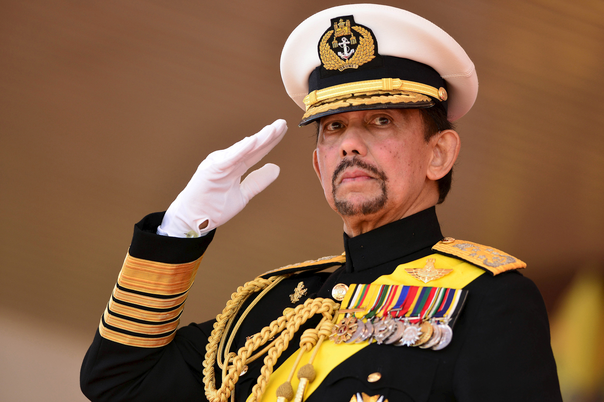 Brunei's Sultan Hassanal Bolkiah salutes during his 69th birthday celebrations in Bandar Seri Begawan, Brunei, August 15, 2015. Brunei's Sultan Hassanal Bolkiah was born on July 15, 1946. The official birthday celebrations were postponed due to the Sultan's birthday falling in the month of Ramadan, according to local media. REUTERS/Ahim Rani - RTX1OCNE