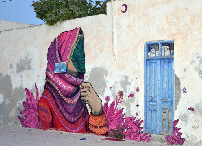 Graffiti decorates the wall of an old house in the Tunisian island of Djerba on July 29, 2014. More than 100 artists from 40 countries were invited by France-based Tunisian artist Mehdi Ben Cheikh to take part in an initiative to turn Djerba's Erriadh district into an open sky museum. AFP PHOTO / F NASRI